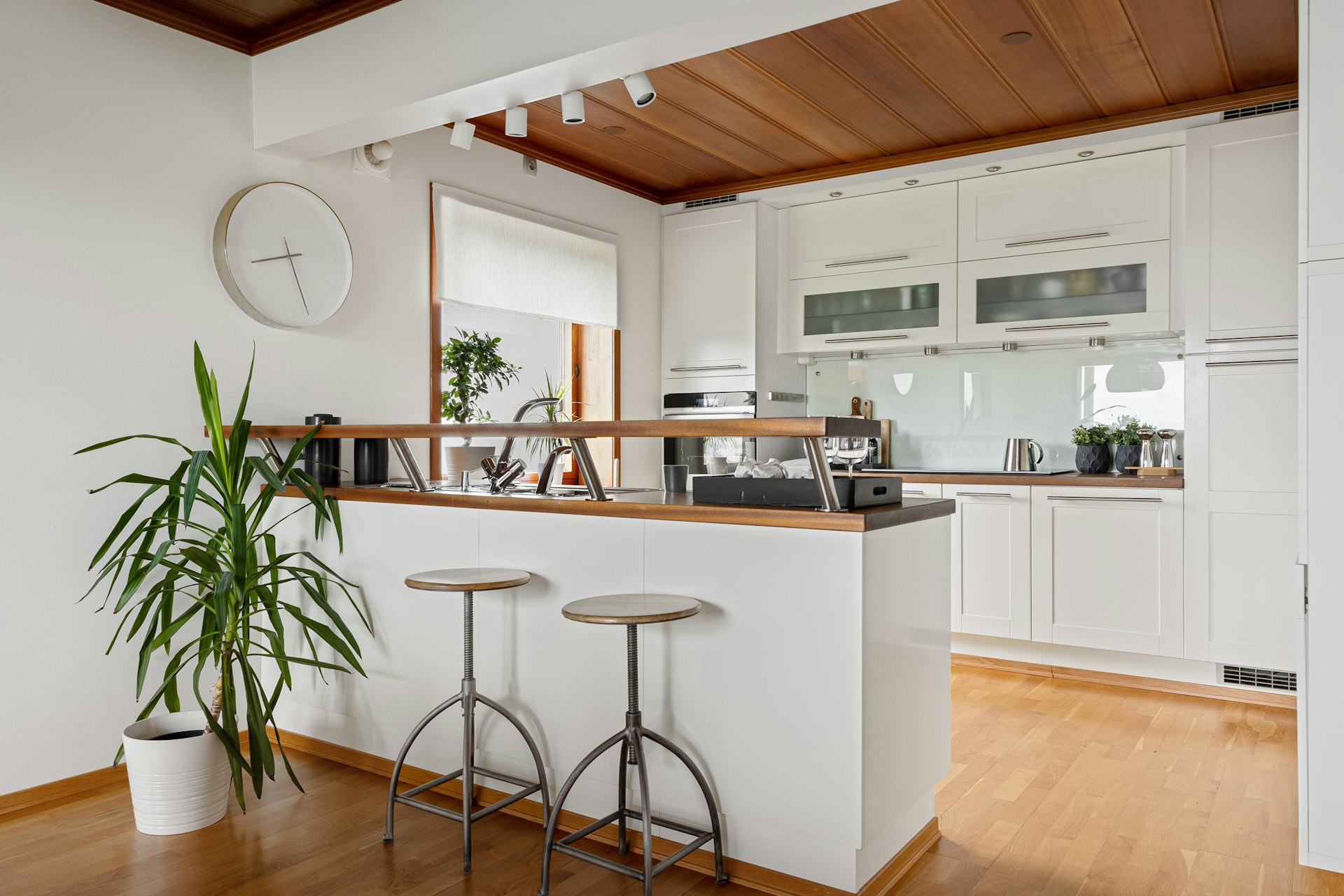 A kitchen with white cabinets and wooden floors